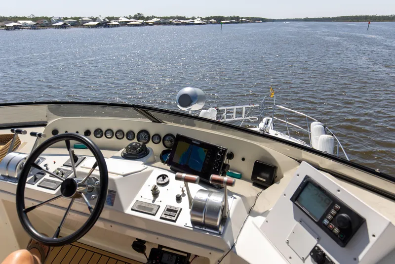 Slide: The Image of Navigator 5600 Sundance Pilothouse 1997 helm with navigation instruments, steering wheel, and water view. - 29
