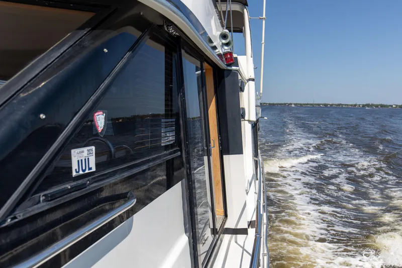 Slide: The Image of Navigator 5600 Sundance Pilothouse cruising on open water, side view, sunny day. - 32