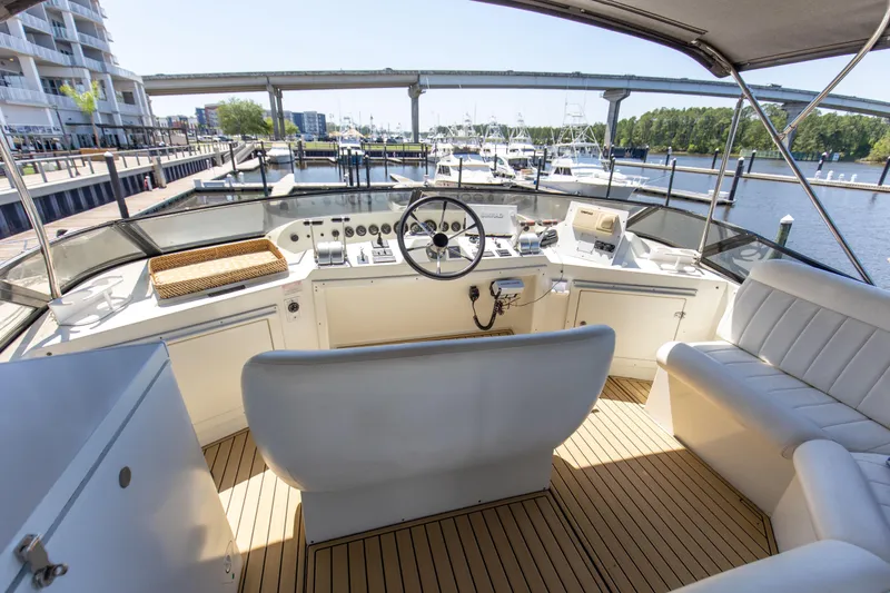 Slide: The Image of Pilothouse of 1997 Navigator 5600 Sundance yacht, featuring helm and seating, docked at marina. - 38