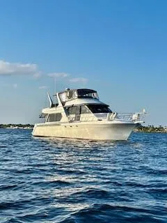 Slide: The Image of 1997 Navigator 5600 Sundance Pilothouse yacht on open water under clear blue sky. - 4