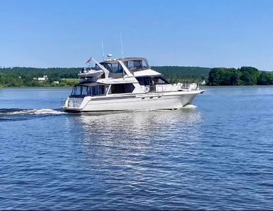 Slide: The Image of 1997 Navigator 5600 Sundance Pilothouse yacht cruising on a calm lake under clear blue skies. - 5