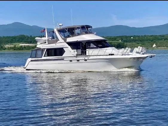 Slide: The Image of Navigator 5600 Sundance Pilothouse yacht cruising on a serene lake, 1997 model. - 6
