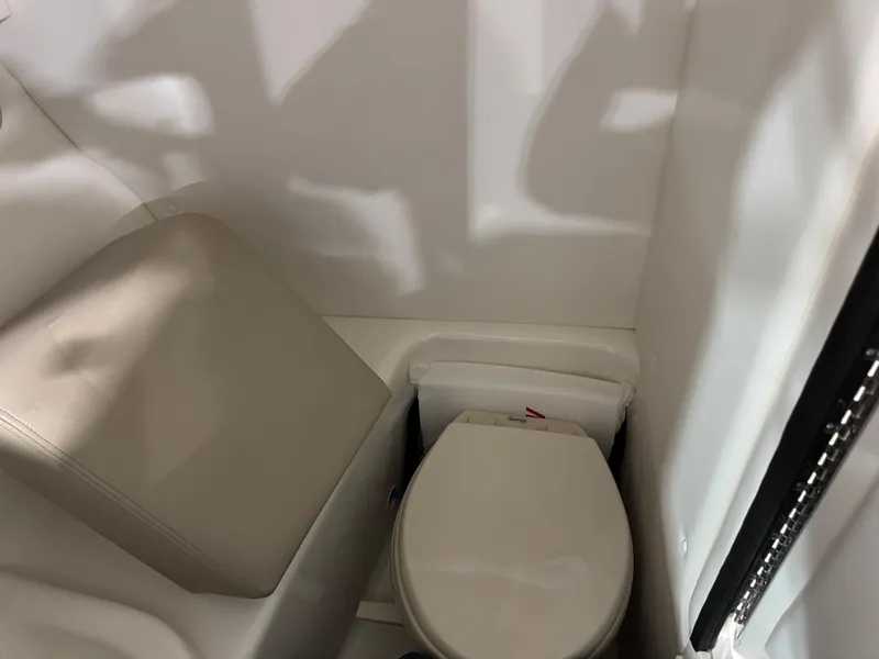 Slide: The Image of 2013 Sea Ray 300 SLX boat interior with compact toilet and seat. - 10