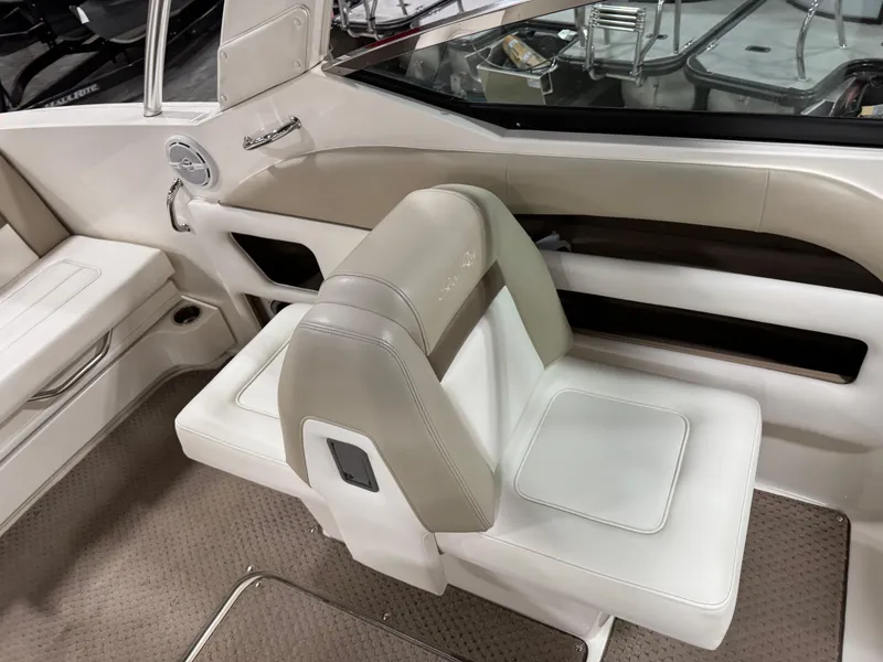 Slide: The Image of 2013 Sea Ray 300 SLX boat interior with beige seating and carpeted flooring. - 12