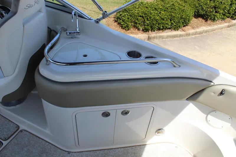Slide: The Image of 2007 Sea Ray 240 Sundeck interior with sink, cup holders, and storage compartment. - 16
