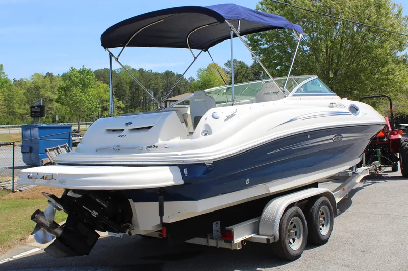 Slide: The Image of 2007 Sea Ray 240 Sundeck boat on trailer with blue canopy, parked outdoors. - 7