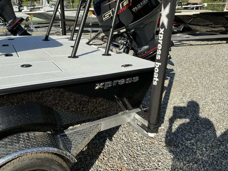 Slide: The Image of 2025 Xpress Skiff 185 boat on trailer, featuring Yamaha engine, parked on gravel. - 7