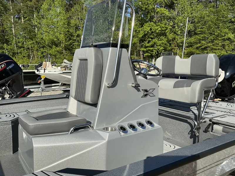 Slide: The Image of 2025 Xpress Hyper-Lift Series H20B boat console with seating, in a wooded outdoor setting. - 5