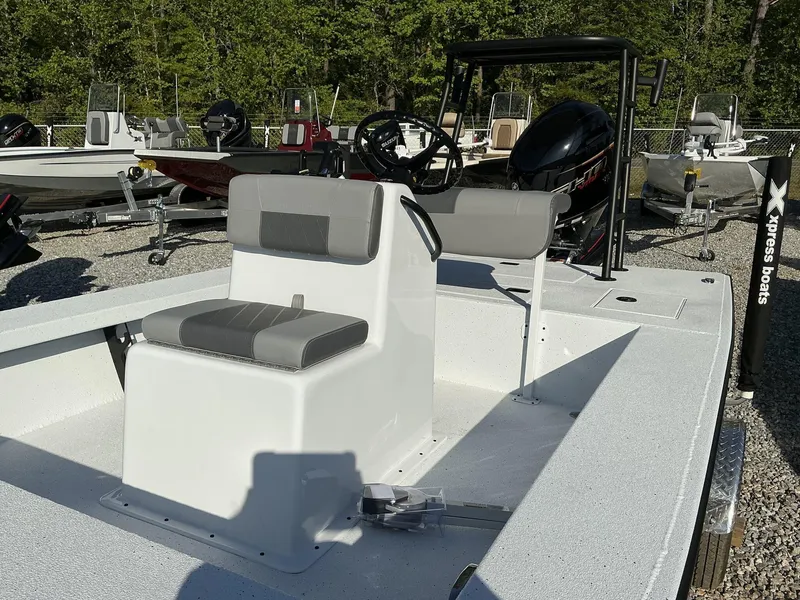 Slide: The Image of 2025 Xpress Skiff 185 boat with seating and steering console, displayed outdoors. - 4
