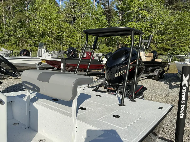 Slide: The Image of 2025 Xpress Skiff 185 boat with outboard motor, displayed outdoors. - 5