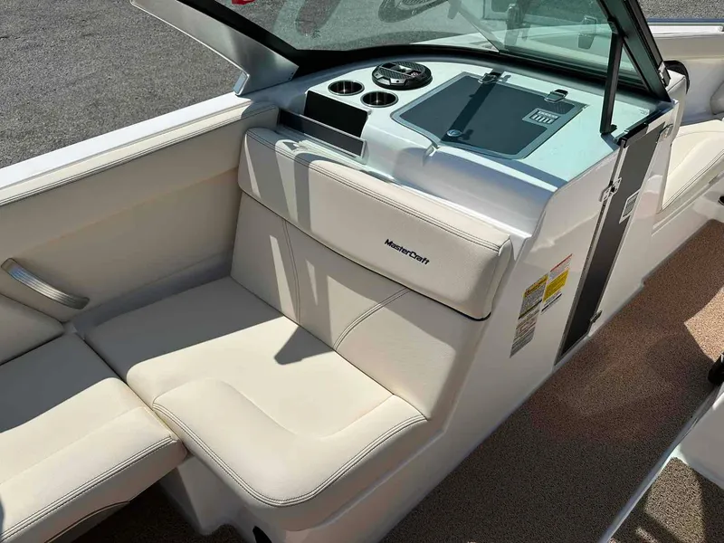Slide: The Image of 2022 MasterCraft XT25 boat interior with white seating and dashboard. - 11
