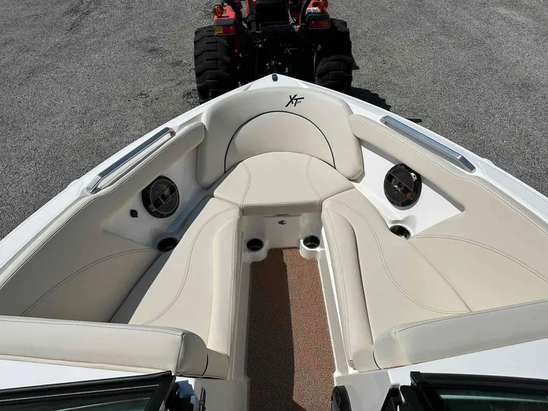 Slide: The Image of 2022 MasterCraft XT25 boat interior with beige seating and speakers. - 14