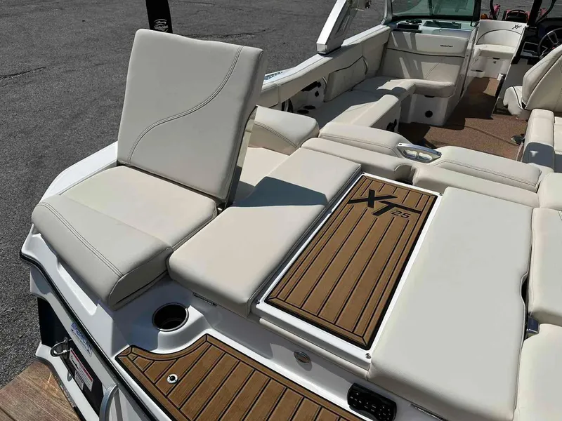 Slide: The Image of 2022 MasterCraft XT25 boat interior with luxurious seating and teak flooring. - 9