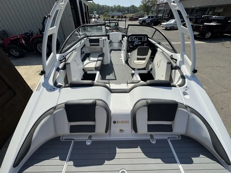Slide: The Image of 2020 Yamaha AR210 boat interior with seating and steering console, docked outdoors. - 12