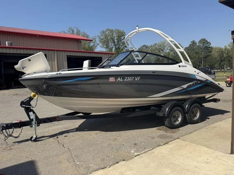 Slide: The Image of 2020 Yamaha AR210 boat on trailer, parked outdoors near a red-roofed building. - 4