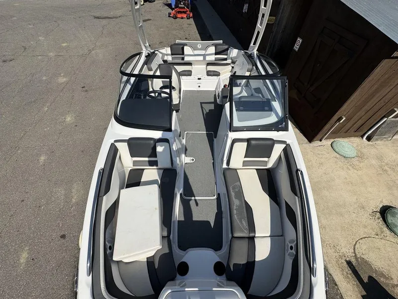 Slide: The Image of 2020 Yamaha AR210 boat interior with seating and dashboard, docked outdoors. - 6