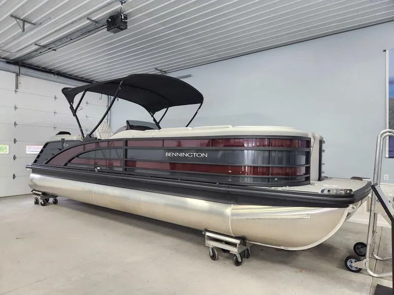 Slide: The Image of 2023 Bennington Marine 25RFBST pontoon boat in a garage setting. - 1