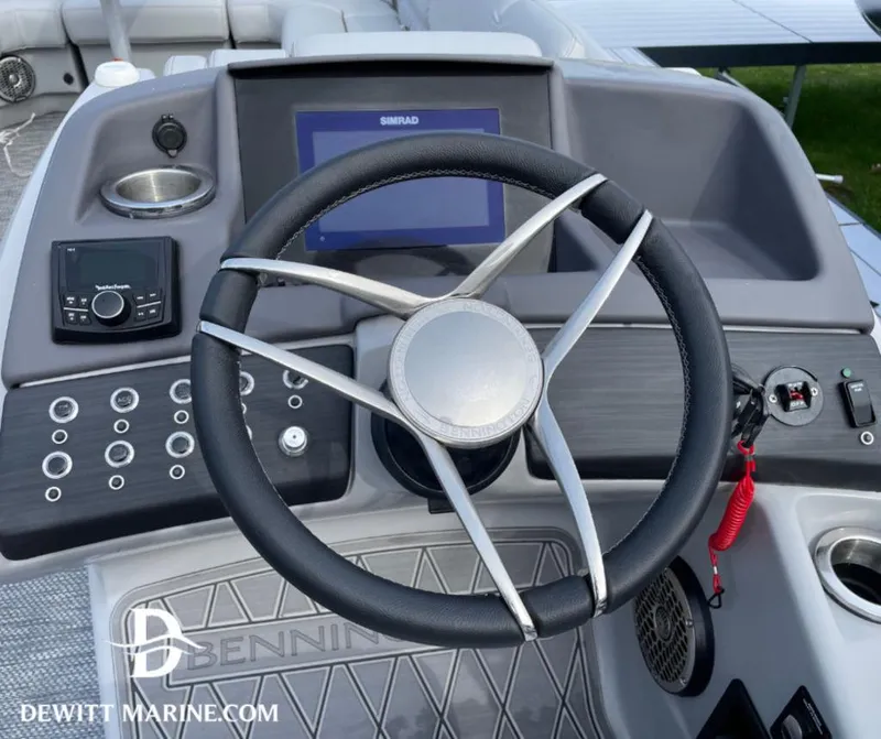 Slide: The Image of 2023 Bennington 25RFBST boat helm with steering wheel, control panel, and Simrad display. - 6