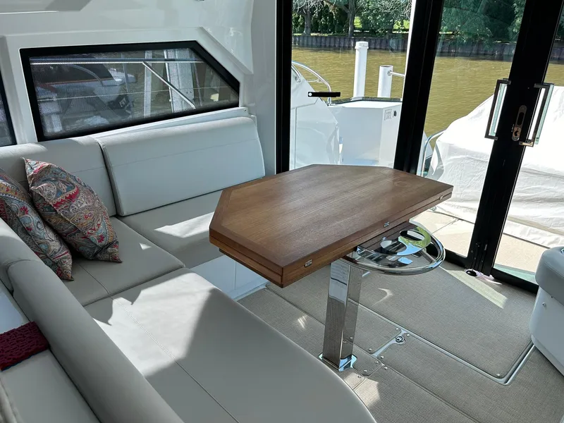 Slide: The Image of Luxurious interior of 2019 Beneteau Gran Turismo 46 yacht with elegant seating and wooden table. - 12