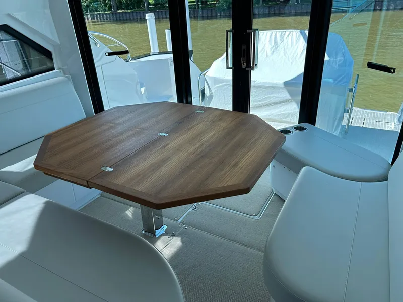 Slide: The Image of Interior of 2019 Beneteau Gran Turismo 46 with wooden table and white seating. - 13