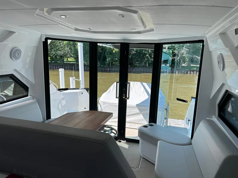 Slide: The Image of Interior view of 2019 Beneteau Gran Turismo 46 yacht with modern seating and river backdrop. - 15