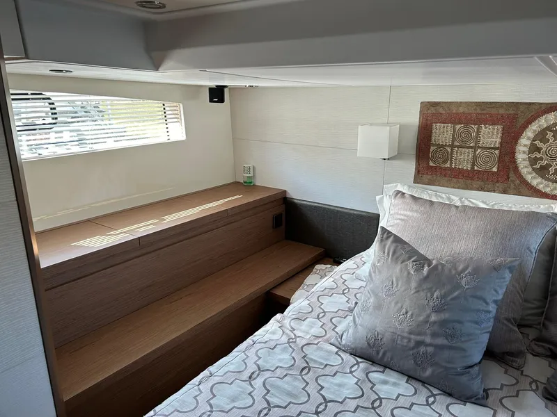 Slide: The Image of 2019 Beneteau Gran Turismo 46 cabin interior with bed, window, and decorative pillows. - 22