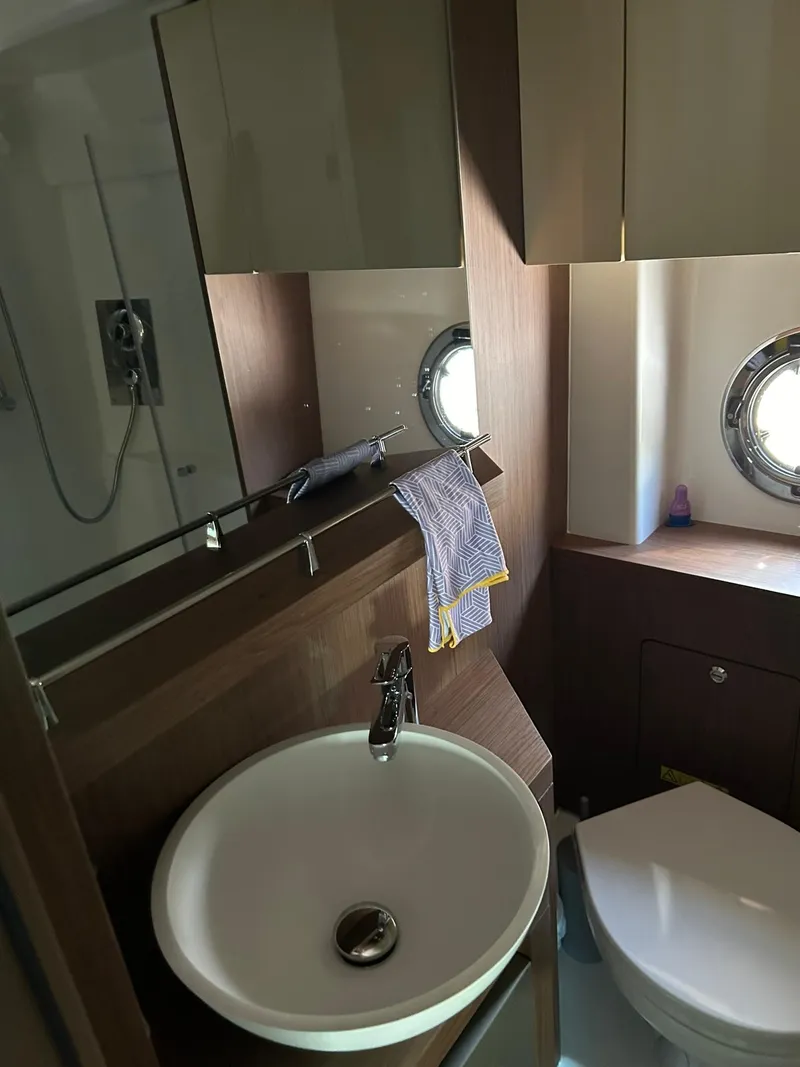 Slide: The Image of 2019 Beneteau Gran Turismo 46 bathroom with sink, shower, and porthole window. - 31