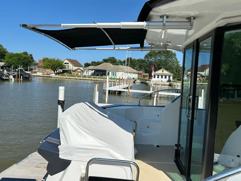 Slide: The Image of 2019 Beneteau Gran Turismo 46 yacht docked by waterfront homes under clear blue sky. - 4