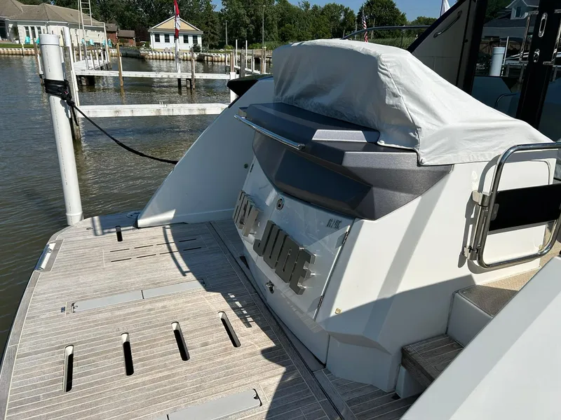 Slide: The Image of 2019 Beneteau Gran Turismo 46 yacht stern view at dock, featuring covered seating area. - 6