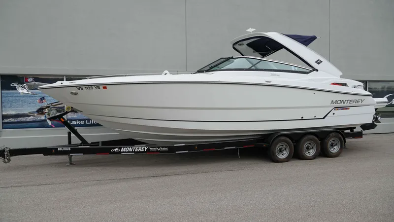 Slide: The Image of 2016 Monterey 328SS boat on trailer, side view, parked outdoors. - 1