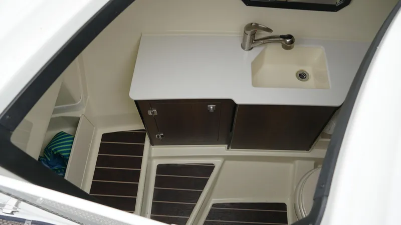 Slide: The Image of 2016 Monterey 328SS boat interior with sink, cabinet, and wooden flooring. - 15