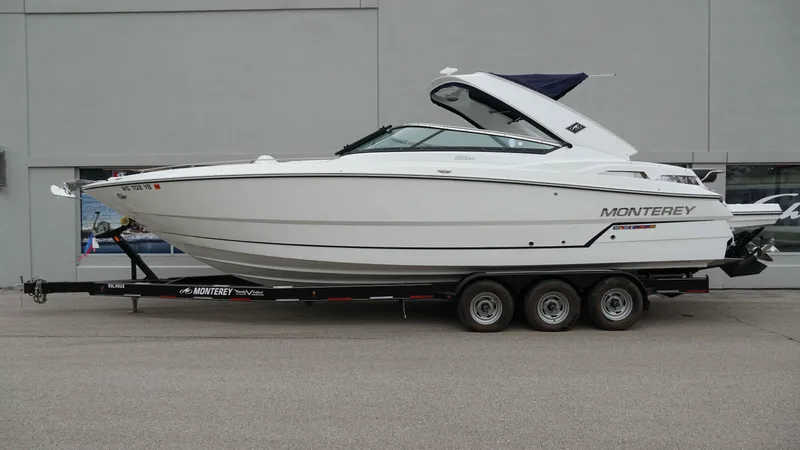 Slide: The Image of 2016 Monterey 328SS boat on trailer, side view, parked outdoors. - 2