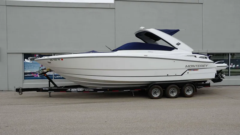 Slide: The Image of 2016 Monterey 328SS boat on trailer, parked outside a building. - 4