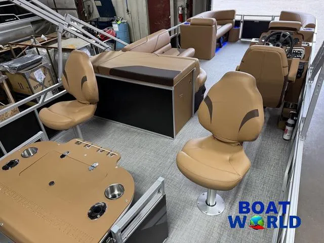 Slide: The Image of 2025 Tahoe Sport 2385 Tritoon interior with tan seating and fishing setup. - 22