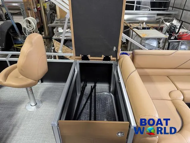 Slide: The Image of 2025 Tahoe Sport 2385 Tritoon interior with storage compartment and tan seating. - 23