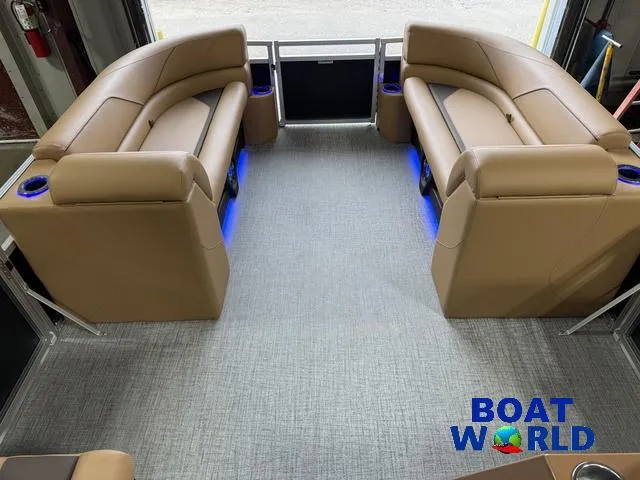 Slide: The Image of 2025 Tahoe Sport 2385 Tritoon interior with tan seating and blue LED lighting. - 28