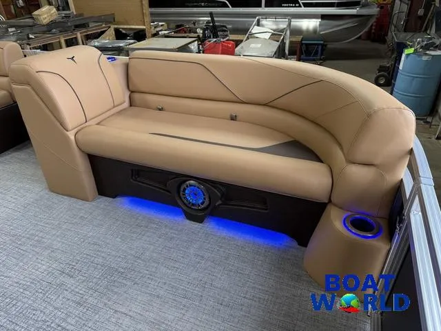 Slide: The Image of 2025 Tahoe Sport 2385 Tritoon interior with tan seating and blue LED lighting. - 32