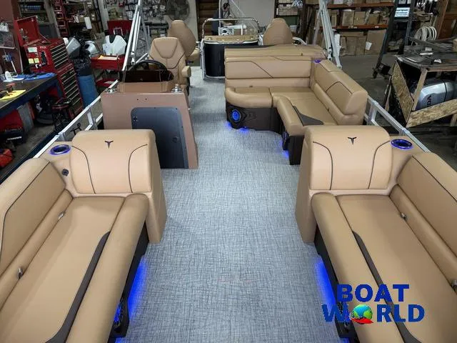 Slide: The Image of Luxurious 2025 Tahoe Sport 2385 Tritoon interior with tan seating and blue LED lighting. - 7