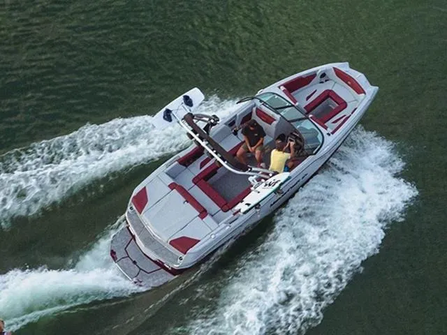 Slide: The Image of 2023 MasterCraft NXT22 boat cruising on water, aerial view. - 1