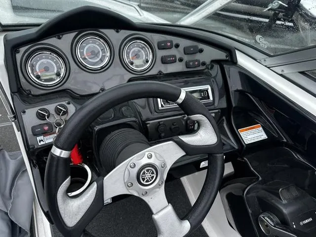 Slide: The Image of Steering console of a 2012 Yamaha Boats 212X, featuring gauges and controls. - 10