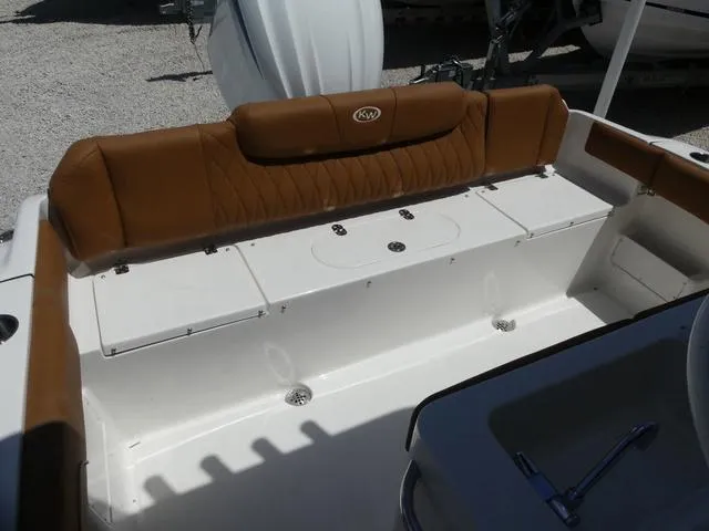 Slide: The Image of 2025 Key West 239 FS boat interior with brown cushioned seating and storage compartments. - 13