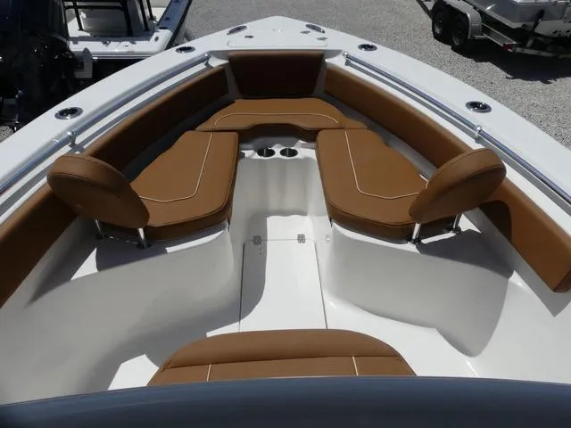 Slide: The Image of 2025 Key West 239 FS boat interior with brown cushioned seating and cup holders. - 16