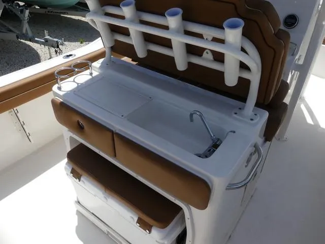 Slide: The Image of 2025 Key West 239 FS boat console with rod holders, sink, and storage compartments. - 7