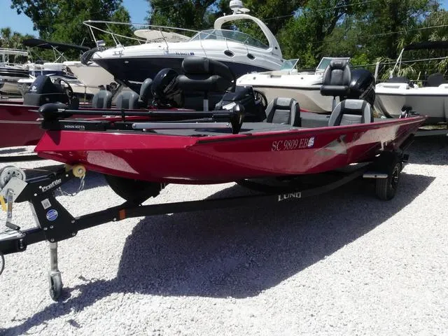 Slide: The Image of 2022 Lund 2175 Pro V boat in vibrant red, parked on a gravel lot. - 3