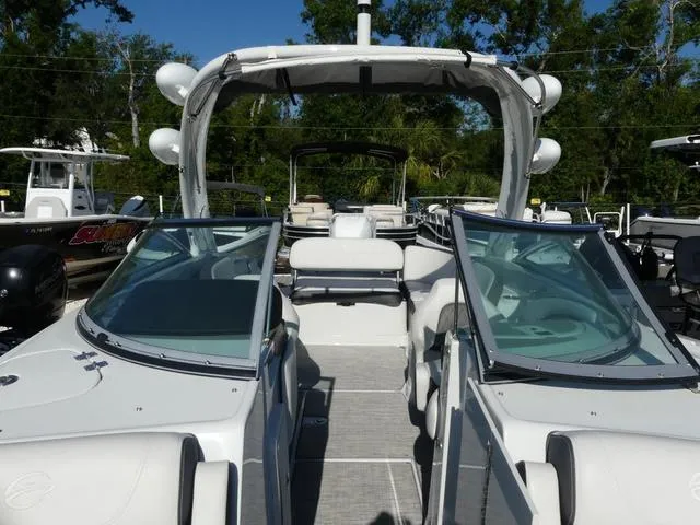 Slide: The Image of 2023 Crownline 290 XSS boat with open cockpit and seating, surrounded by trees. - 14