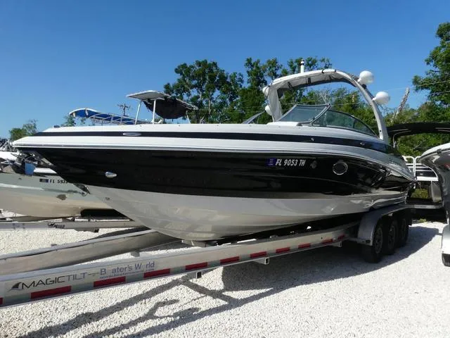 Slide: The Image of 2023 Crownline 290 XSS boat on trailer, black and white design, parked outdoors. - 3