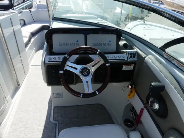 Slide: The Image of 2023 Crownline 290 XSS boat dashboard with Garmin displays and steering wheel. - 7