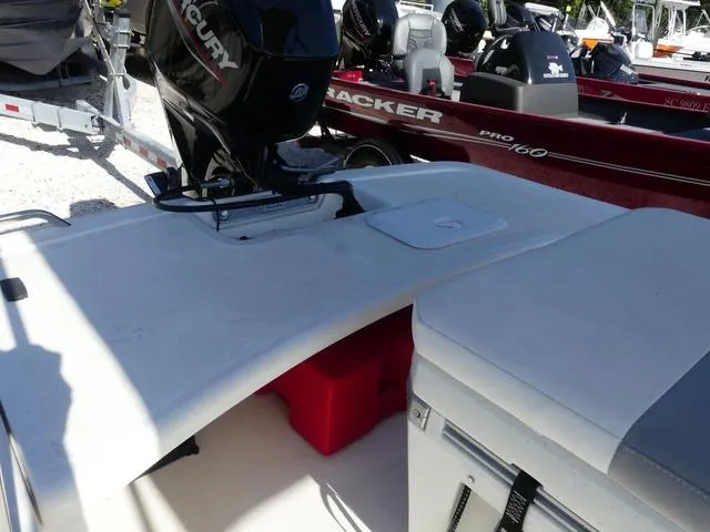 Slide: The Image of 2024 Mako Pro Skiff 15 CC boat with Mercury engine, docked alongside other boats. - 10