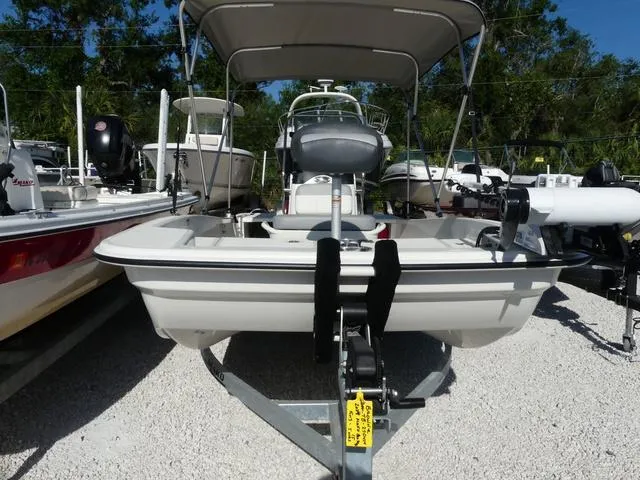 Slide: The Image of 2024 Mako Pro Skiff 15 CC boat on trailer, parked outdoors, surrounded by other boats. - 2