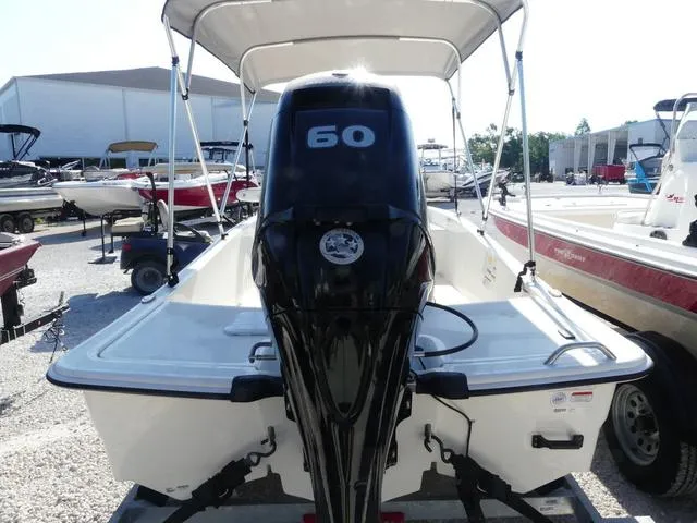 Slide: The Image of 2024 Mako Pro Skiff 15 CC with 60 HP engine, parked in a boatyard. - 5